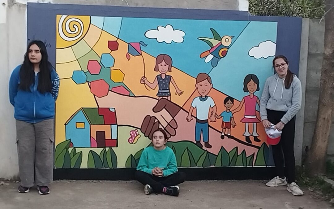 ALUMNAS DEL TALLER DE CREACIÓN PLÁSTICA DE LA EMAC PINTARON UN MURAL SOBRE INFANCIA Y COMUNIDAD EN LA SEDE DE ANIN