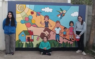 ALUMNAS DEL TALLER DE CREACIÓN PLÁSTICA DE LA EMAC PINTARON UN MURAL SOBRE INFANCIA Y COMUNIDAD EN LA SEDE DE ANIN